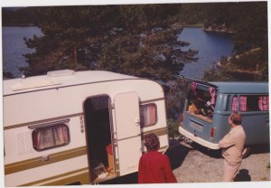 Stord 1980. Vi parkerte vogn i oppkjørselen til Harald og Hjørdis. Gunvor og Sigfred foran vogna. Hans og Gunhild sin vogn Knaus, nesten ny. VW Caravelle. Campingvogna(Knaus) fikk vi låne av Hans og Gunhild - tilbød oss vogna uten at vi spurte. Den var bare to år gammel så det var nifse greier.  Vi hentet deg på Trondsletten. Bilen var blå VW Caravelle. Vi fikk den plassert hos Harald og Hjørdis - fikk den dratt opp til plassen av en liten bil, og måtte snu den for hånd. Bak vogna er det stup på flere meter. Foto: Privat
